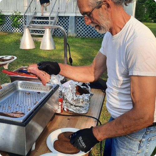 Traiteur de méchoui au Québec servant des viandes grillées au feu de bois d'érable lors d'un évènement en plein air - Méchoui du Marquis